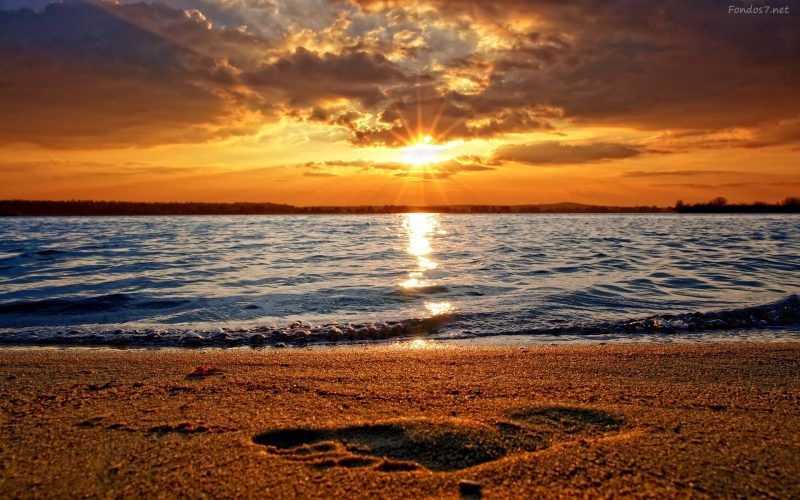 atardecer-en-la-playa-con-pisada-en-la-arena