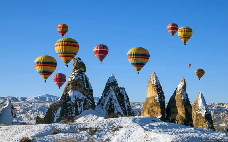 Globos de colores sobrevolando las montañas heladas